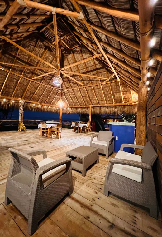 Sala y comedor bajo palapa de noche
