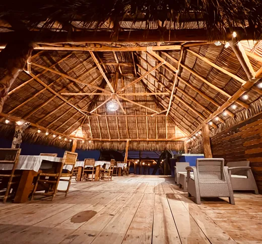 Area de comedor del club de playa bajo palapa de noche