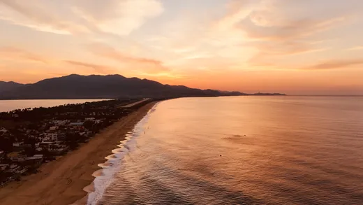 Vista aerea de la playa y el pueblo al atardecer
