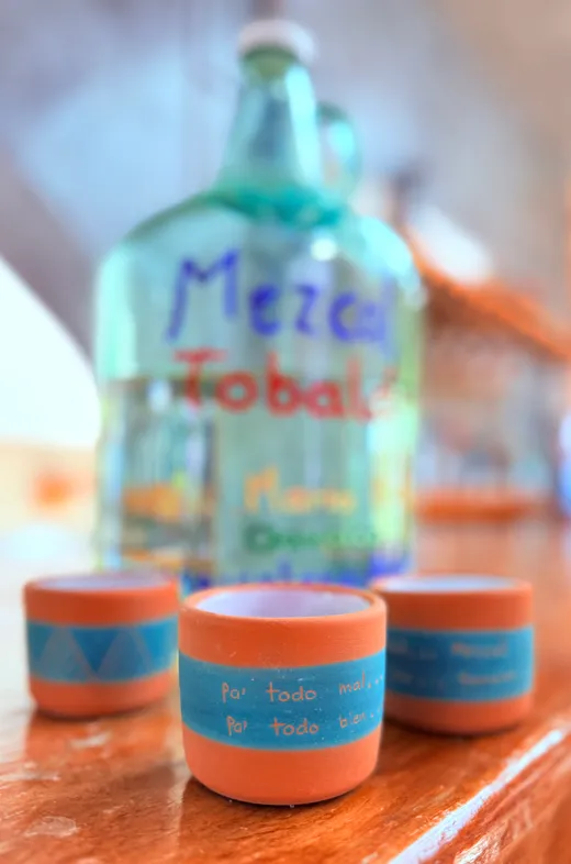 Mezcal artesanal Tobala servido con vasitos de barro