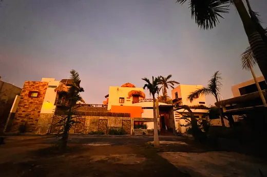 Fachada del hotel al atardecer entre palmeras