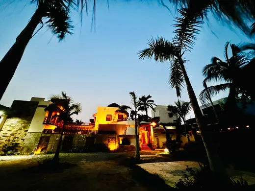 Entrada del hotel entre palmeras de noche