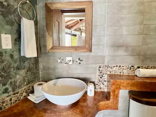 Baño con lavabo de piedra y mosaico de piedra