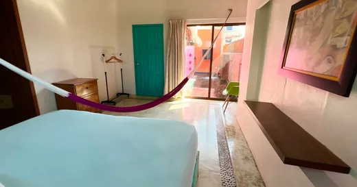 Habitacion con hamaca y vista al patio de la alberca