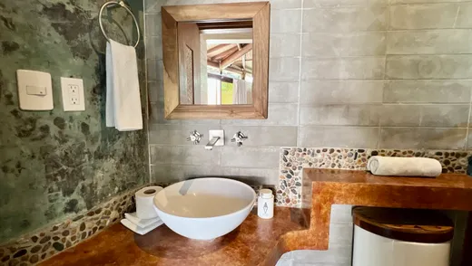 Bano con lavabo de piedra y mosaico de piedra